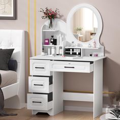 a white vanity table with drawers and a round mirror on it's facet