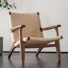 a wooden chair sitting on top of a hard wood floor next to a potted plant