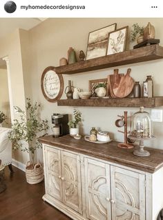 a kitchen counter with some shelves above it and pictures on the wall behind it, along with other items