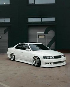 a white car parked in front of a garage