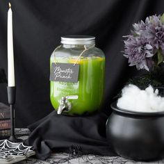 there is a green liquid in a jar next to a candle and some other items