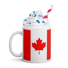 a coffee mug with whipped cream and a canadian flag design on it, filled with sprinkles