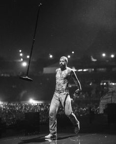 a man standing on top of a stage holding a baseball bat in his right hand