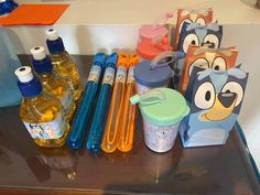 an assortment of toothbrushes, bottles and other items on top of a table