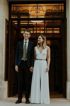 a man and woman standing in front of a building