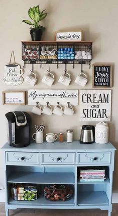 a blue table with coffee cups and mugs hanging on the wall next to it