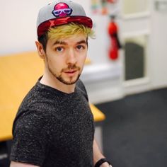 a young man with blonde hair wearing a baseball cap