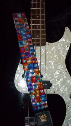 an electric guitar with a colorful beaded neck