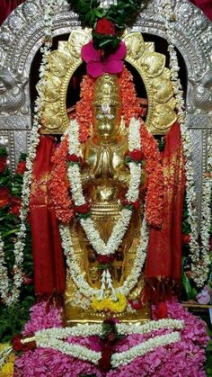 the statue is surrounded by flowers and garlands