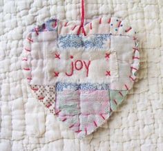 a heart shaped ornament with the words joy on it