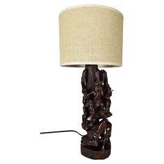 a wooden table lamp with a beige shade on it's base and an elephant figurine