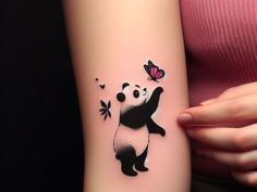 a woman's arm with a panda bear tattoo on it and butterflies flying around