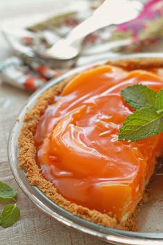 a piece of pie on a plate with some mint leaves