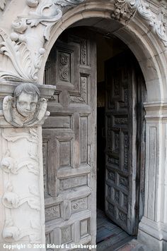 an old door with carvings on it and a carved face above the door is shown