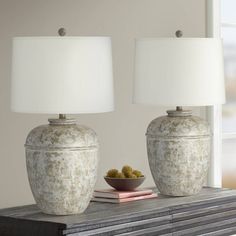 two lamps sitting on top of a table next to a bowl with food in it