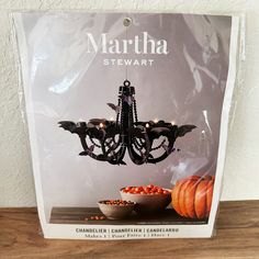 a halloween chandelier with bats hanging from it's arms and pumpkins in the bowl