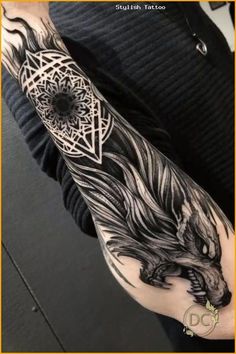 a man's arm with an intricate tattoo design on the left forearm and shoulder