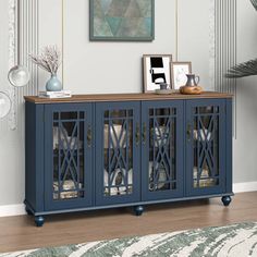 a large blue cabinet with glass doors in a living room next to a painting on the wall