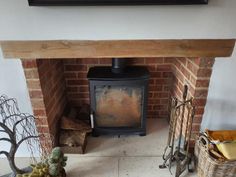 a wood burning stove sitting inside of a living room next to a basket filled with plants