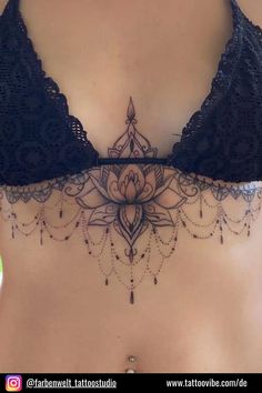 a close up of a woman's stomach with tattoos on her chest and bra