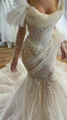 a woman in a wedding dress is posing for the camera