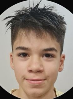 a young boy with black hair is smiling for the camera in a round photo frame