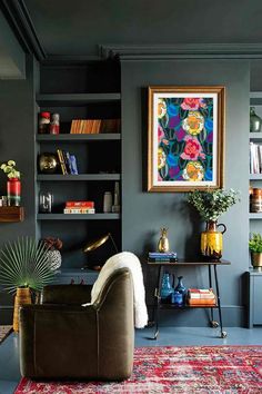 a living room filled with furniture and bookshelves next to a painting on the wall