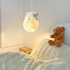 a teddy bear sitting on top of a bed under a light