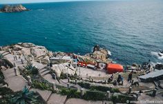 an aerial view of the ocean with people walking around