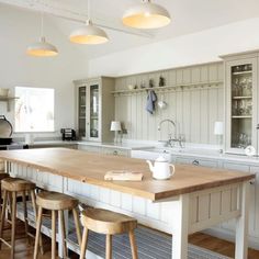 a large kitchen island with stools in the middle and an oven on the other side