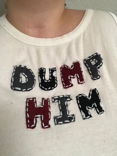 a person wearing a white shirt with black and red letters that spell out hump him