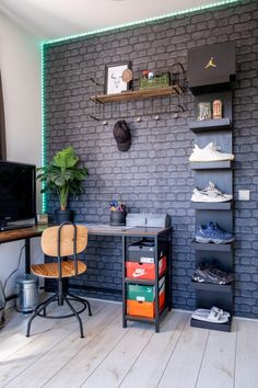 a room with a brick wall and shelves filled with shoes, bookshelves and a desk