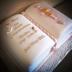 a cake that is sitting on top of a doily covered table with an open book