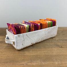 a metal container filled with lots of different colored cards