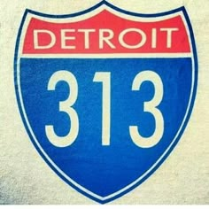 a close up of the detroit 31 3 logo on a white wall with red and blue lettering