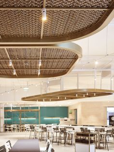 an empty table and chairs in a large room with lots of lights hanging from the ceiling