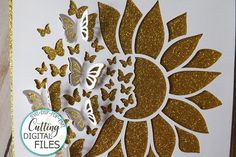 a card with gold glitter butterflies and a sunflower in the center, on top of a white background