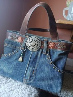 a handbag made out of old jeans with an embellishment on the front