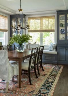 a dinning room table with chairs and a bench in front of the dining room window