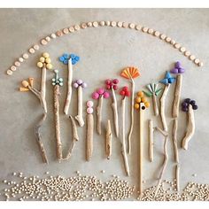 several wooden sticks are arranged in the shape of flowers and leaves, with beads around them