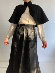 This wonderful textile is an antique French capelet, dating to the late 1800s. The black material is a beautiful textured silk blend fabric. This textile would have been worn about the shoulders as a stylish accent. It fastens at the neck with 2 metal hook and eye clasps. The collar is lined with a heave linen to keep it stiff, you can see it becuase the black fabric has come loose at the back of the neck. The rest of the cape is not lined, but the simple seams are reinforced with a kind of nett Formal Black Capelet, Black Capelet For Costume, Elegant Black Formal Capelet, Elegant Black Capelet For Costume, Victorian Capelet, Lace Apron, French Workwear, Shoulder Cape, Embroidered Bodice