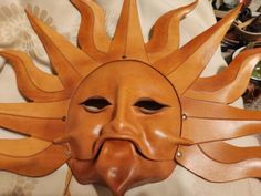 a wooden mask that looks like the sun