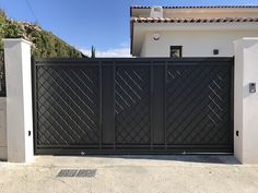 a black gate in front of a white house