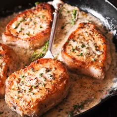 four pieces of meat in a skillet with a spoon