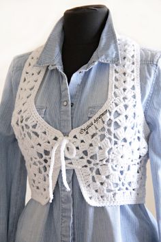 a blue shirt with white crochet on it and a black mannequin