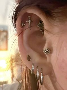 a close up of a person's ear with several different types of piercings