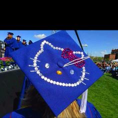 a blue graduation cap with a hello kitty design on the front and pearls in the middle