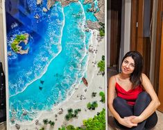 a woman sitting on the floor next to an aerial view of a beach and ocean