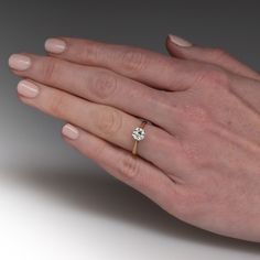 a woman's hand with a diamond ring on it