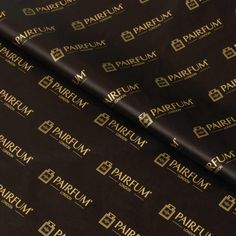 black and gold foiled wrapping paper with the word parfum on it's side